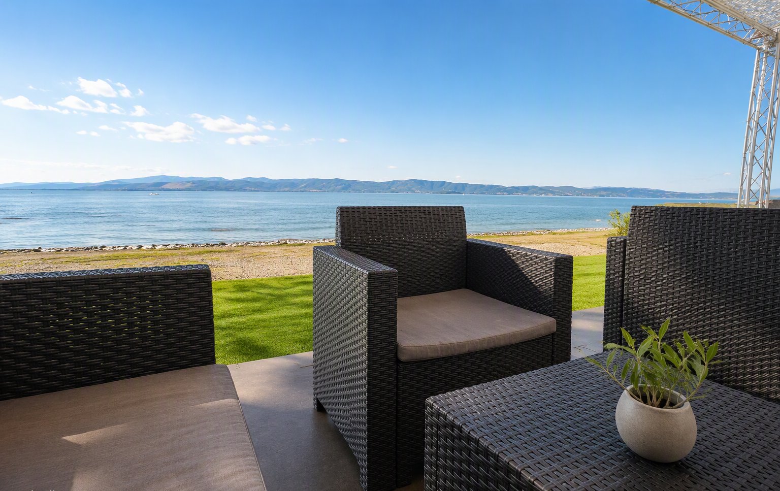 Il lounge all'aperto con le poltrone in vimini vista lago